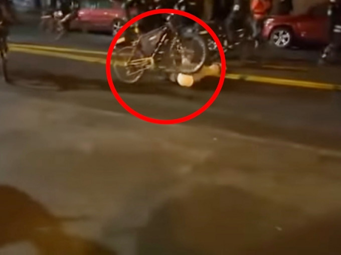 单车的前轮和后轮都辗过该名示威者的头部。影片截图