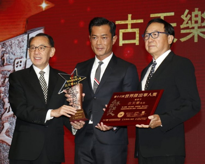 古天樂從楊受成及許冠文手上接過世界傑出華人獎。
