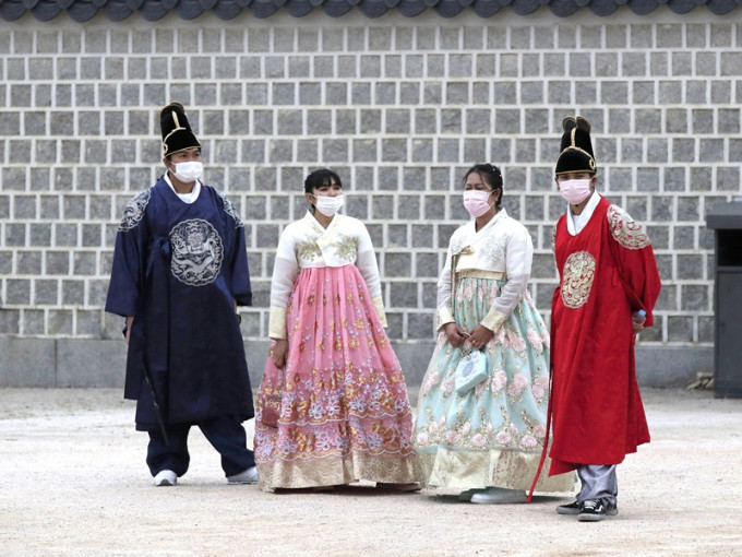 遊人穿上傳統韓國服飾不忘戴上口罩防疫。AP