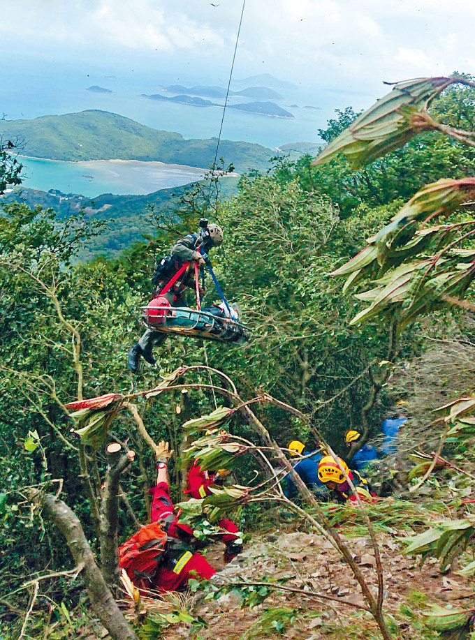 消防處高空拯救專隊，在大嶼山南天門攀山拯救受傷市民，由直升機吊起送院。