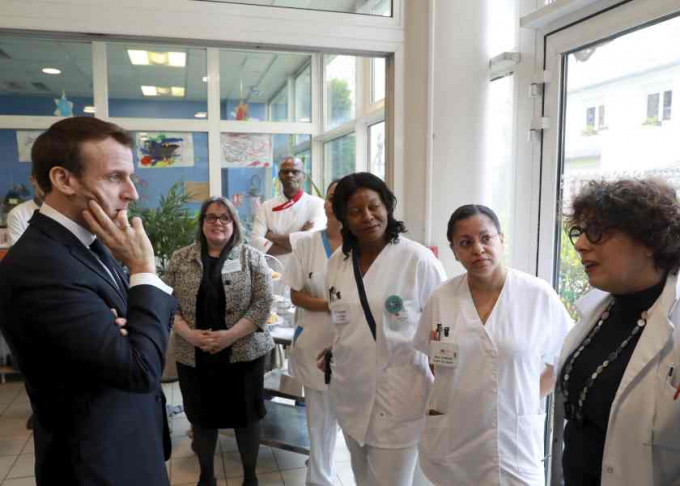 法国总统马克龙到医院了解抗疫工作。AP