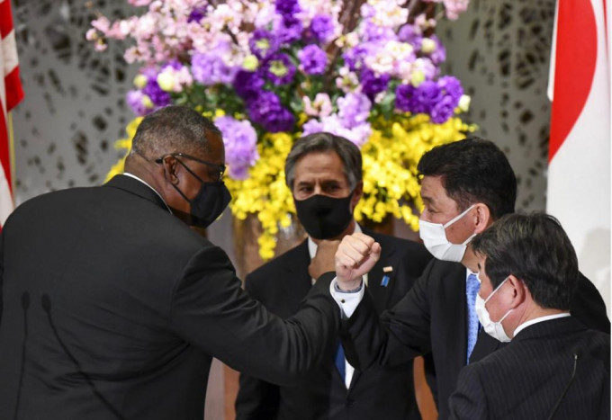 美国国防部长奥斯丁（左1）在东京2+2会谈记者会结束后，与日本防卫大臣岸信夫（右2）碰手。旁为美国国务卿布林肯（后排中）及日本外务大臣茂木敏充（右1）。AP图片