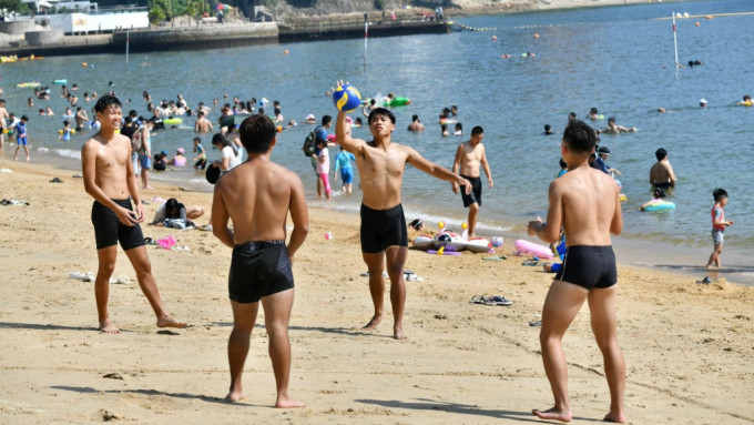 市民在沙滩上玩沙滩排球。