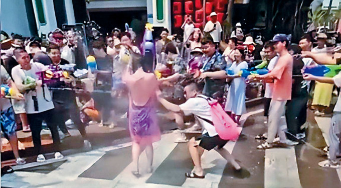 云南西双版纳一名女游客被多名男子包围泼水。