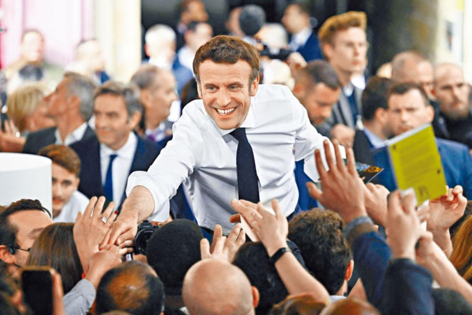 馬克龍周五在法國南部的集會上與支持者握手。