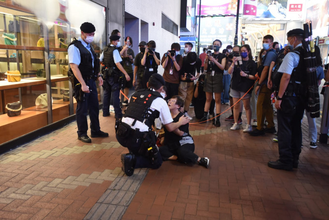 一名身穿黑衣的老妇被警员截查后情绪激动。