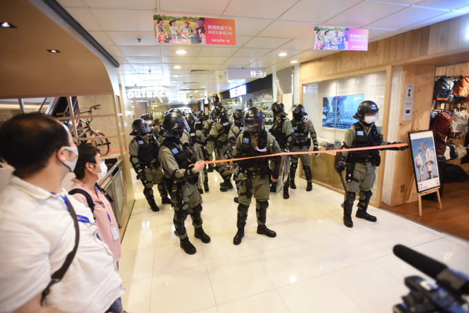 防暴警察进入商场拉起封锁线。