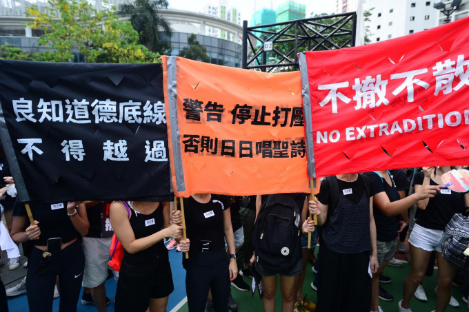 遊行人士舉出標語要求警方促停止使用武力。
