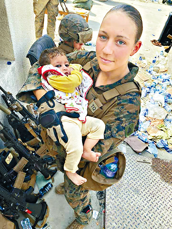 ■美國女兵吉伊抱着阿富汗嬰孩。