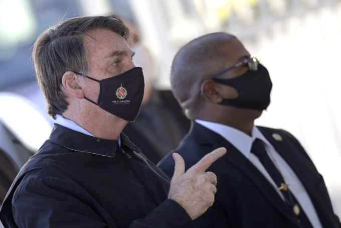 巴西总统博尔索纳罗偶然有戴口罩，但很多时被目睹接触支持者却没有戴口罩。AP图