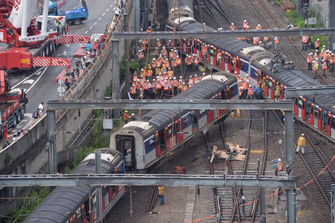 港铁工程人员正将出轨的车厢吊起并扶正。