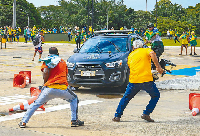 示威者在总统府外，袭击一辆警车。