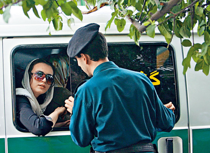德黑蘭一名婦女涉嫌違反服裝規定，被警察拘捕帶上警車。