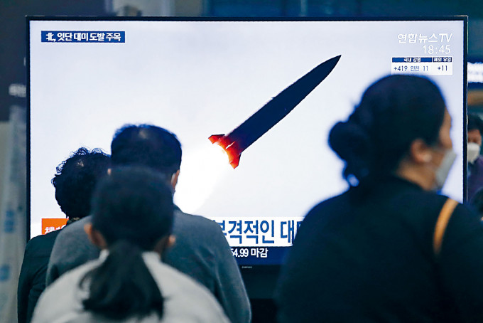 南韩民众周四在首尔水西站大电视，观看北韩试射导弹的新闻报道。