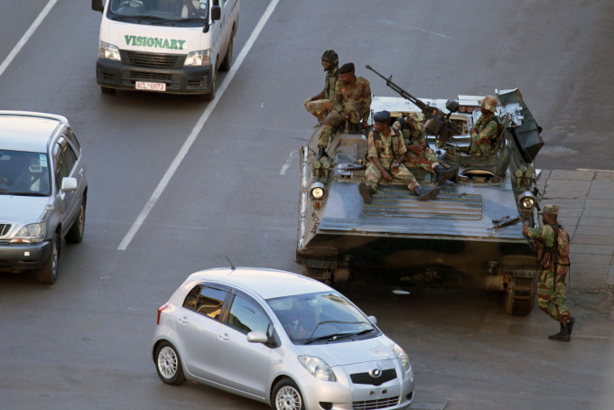 哈拉雷气氛紧张，装甲车和军人在街上架设路障截查车辆。AP