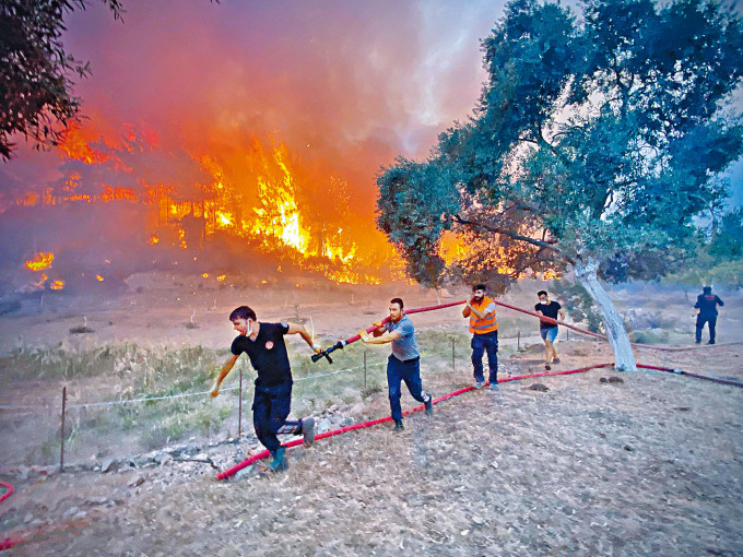 ■土耳其消防员和义工上周五在西南部的木拉省度假地区，抬着灭火喉前往扑火。