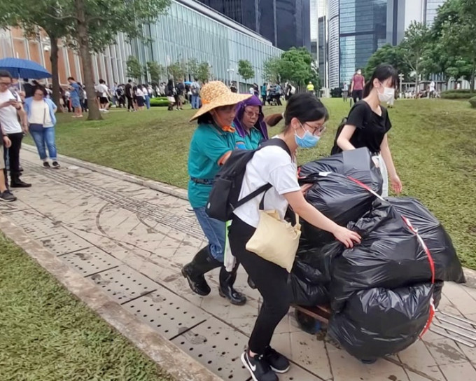 有市民帮忙清洁工人推垃圾车。