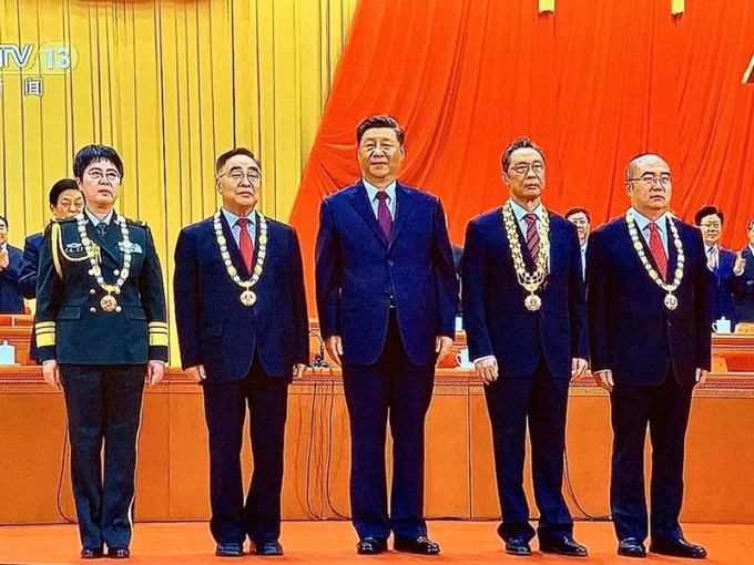 习近平(中)向国家勋章及国家荣誉称号获得者颁授勋章。