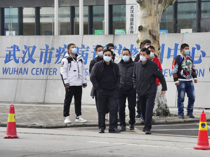 世界卫生组织专家组成员早前到访湖北武汉的疾控中心，多名疑似便衣公安在外巡逻。AP图片