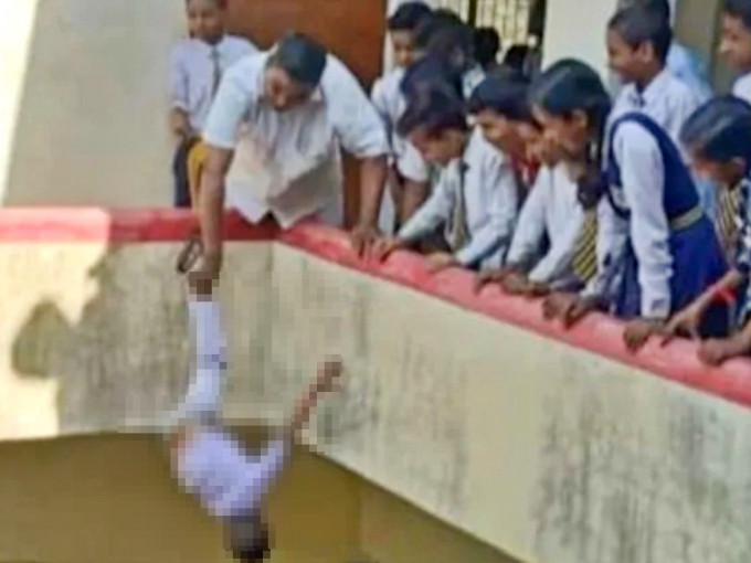 印度初中男生离校买炸脆球，校长认为该学生太过顽皮，竟捉其脚倒吊半空处罚。网图