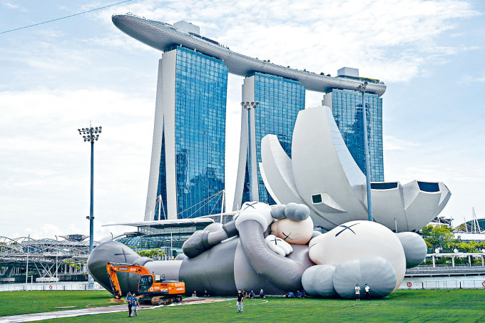 ■周五在新加坡濱海灣《KAWS：假日》展場，仍可見大型吹氣公仔躺臥着。