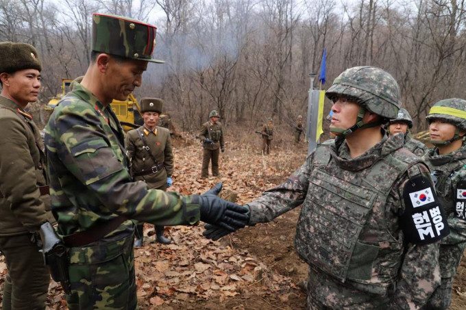 2018年在江原道鐵原郡箭頭高地非軍事區，參與公路修建工作的南北韓軍人在軍事分界線附近握手致意。路透社