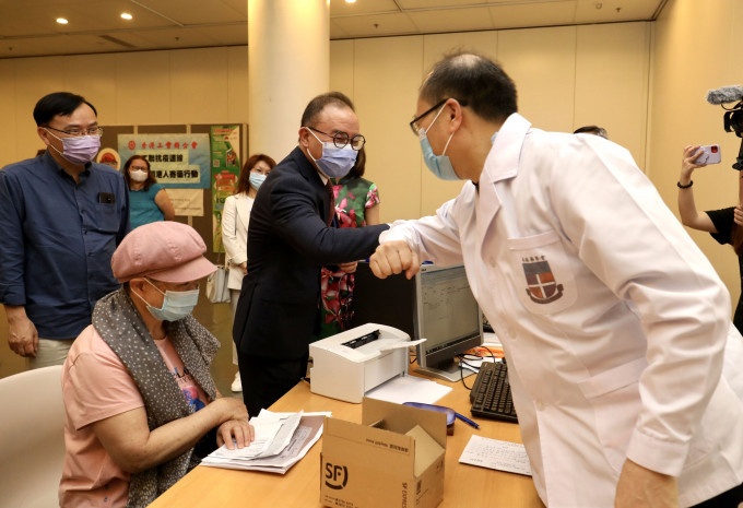 曾国衞（右二）与香港药学服务基金的药剂师打招呼。 政府新闻处图片