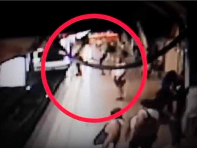 巴西一名怪客在列车进站的时候，突然将一名男子踢落路轨。　影片截图