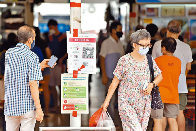 ■新加坡市民进入食肆前以手机扫二维码，留下出行纪录。　