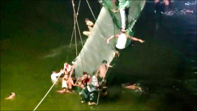 印度西部古吉拉特邦一座吊橋10月30日突然如「脆麻花」般扭曲斷裂，造成100多人喪命。（路透社）