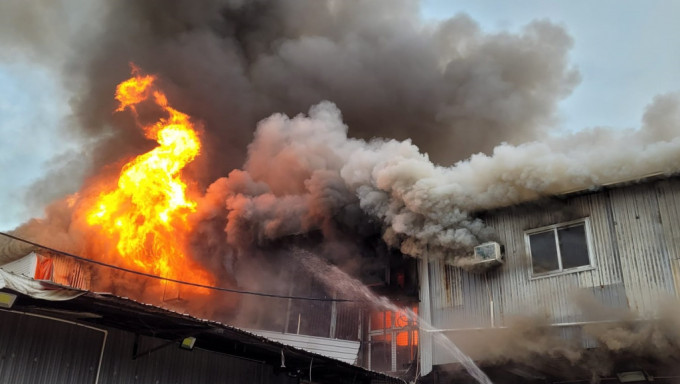 鐵皮屋起火焚燒，濃煙沖天。讀者提供