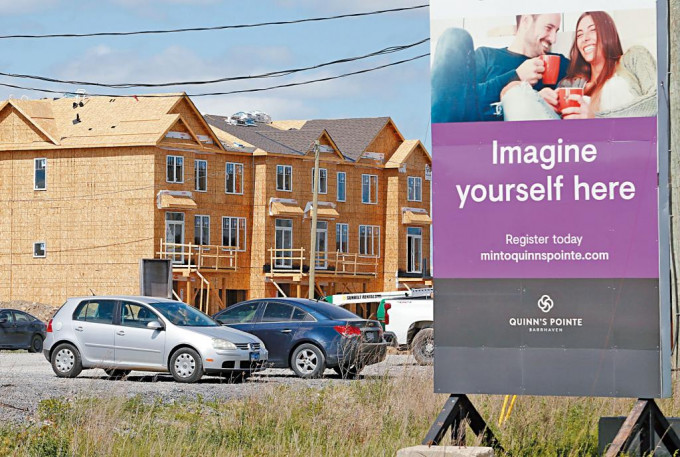 加拿大渥太华去年一些待售新住宅的外围，竖立有地产广告牌。