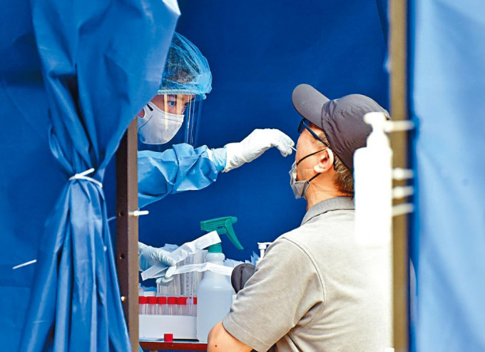 在將軍澳流動採樣站，醫務人員為市民做核酸檢測。