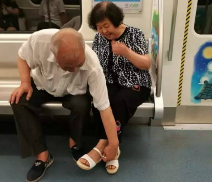 老夫替妻子穿好涼鞋。網上圖片