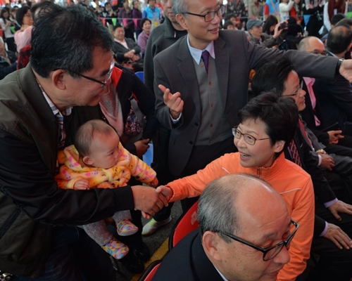 有市民抱着婴儿向林郑握手。