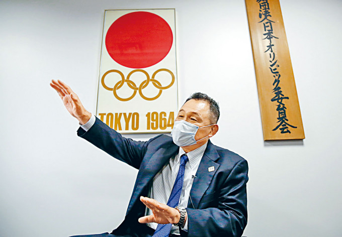 ■日本奧委會主席山下泰裕，周五戴着口罩接受媒體訪問。