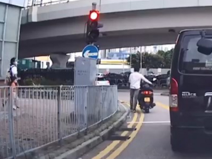 电单车司机遇红灯后，落车用手推过斑马线。「香港突发事故报料区」片段截图