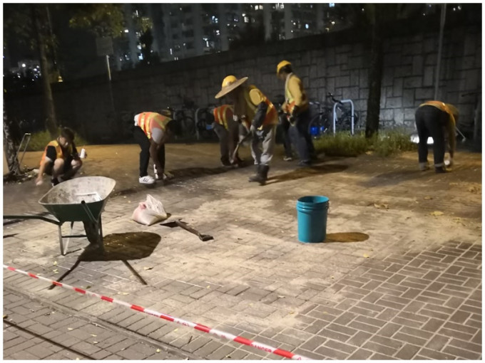 工人晚上在大埔太和路黏街磚。讀者提供