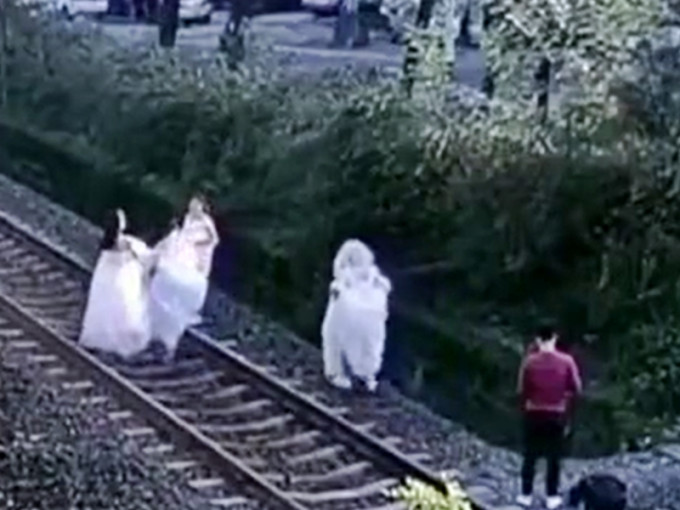 內地近日有一名男攝影師與4名女子，竟跑到火車鐵軌上拍婚紗照。影片截圖
