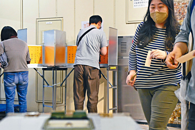 ■东京都议会选举昨日举行，民众在东京一个票站投票。