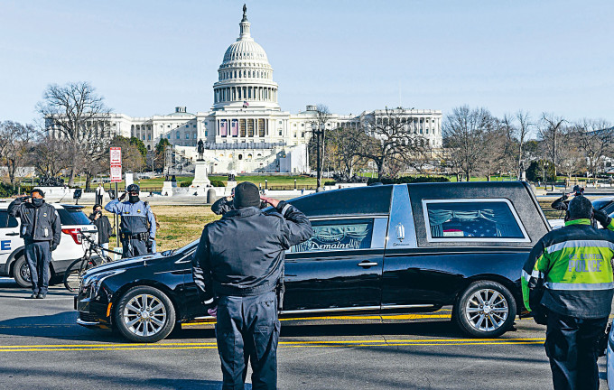载着国会殉职警察西肯尼克灵柩的灵车，周日驶过国会山庄，当值警察向灵车敬礼。　