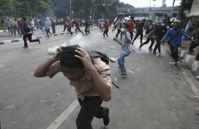 示威學生周三在印尼雅加達示威抗議，被警察發射催淚彈。AP