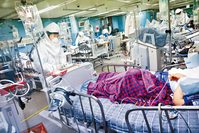 南韩医护在深切治疗病房为新冠患者检查。