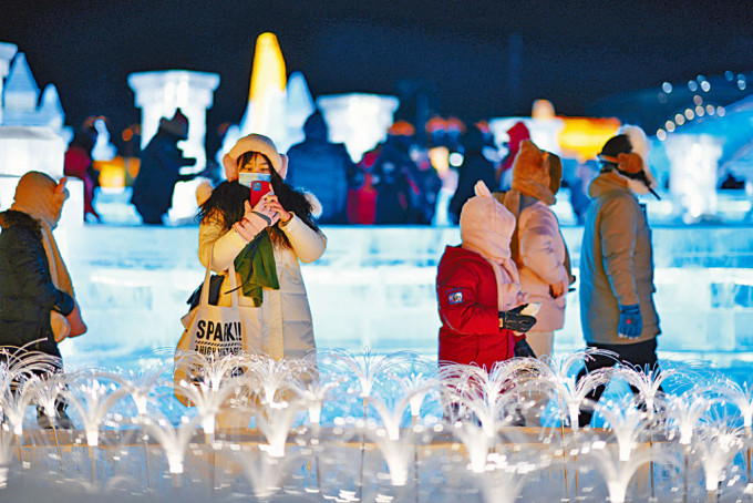 游客在哈尔滨冰雪大世界园区内游玩。