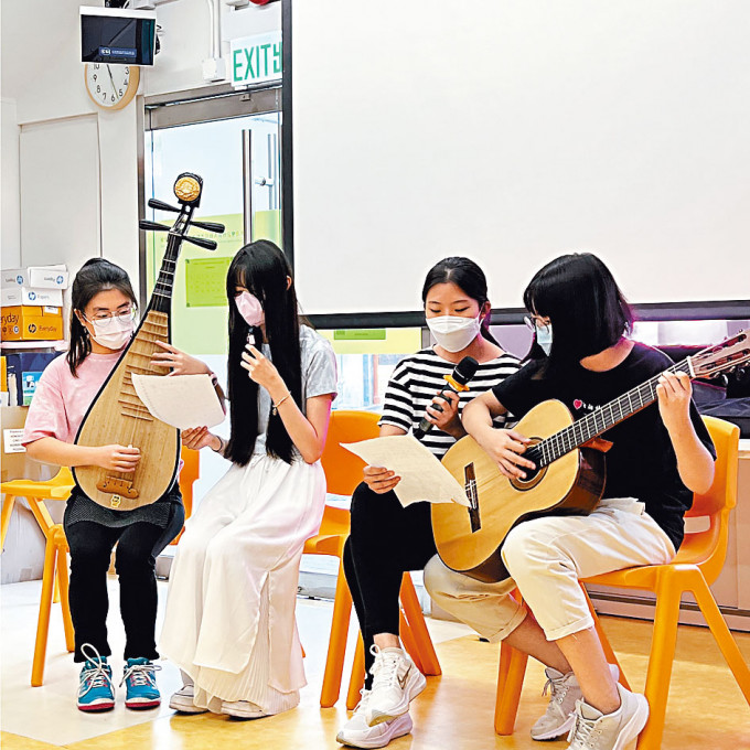就讀中四的小領袖何希婷（左一）帶領組員一起演奏樂器及唱歌予長者欣賞。
