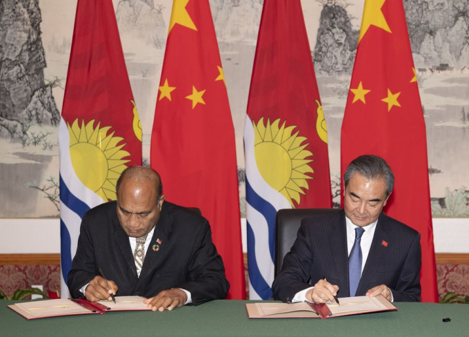 王毅（右）与基里巴斯总统兼外长马茂（左）签署联合公报。