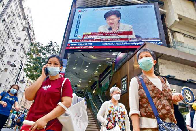 特首林郑在闹市的大屏幕上讲述选举新安排。