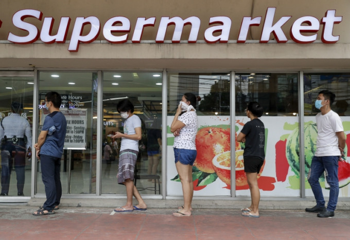 為防範新冠疫情，菲律賓超市民眾排隊購物都需要保持約1米距離。AP