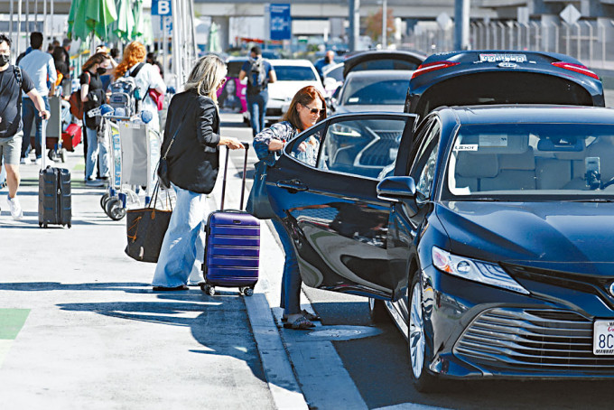 旅客在洛杉矶机场，乘搭Uber网约车。