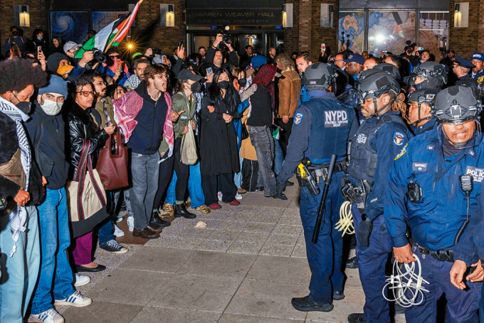 警察在纽约大学拘捕示威者后，与另一群示威者对峙。